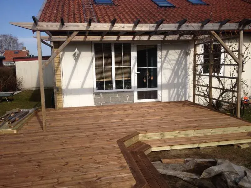 Terrass med räfflade brädor och blomlådor – Bjärred. Utfört av Wood & Stone.