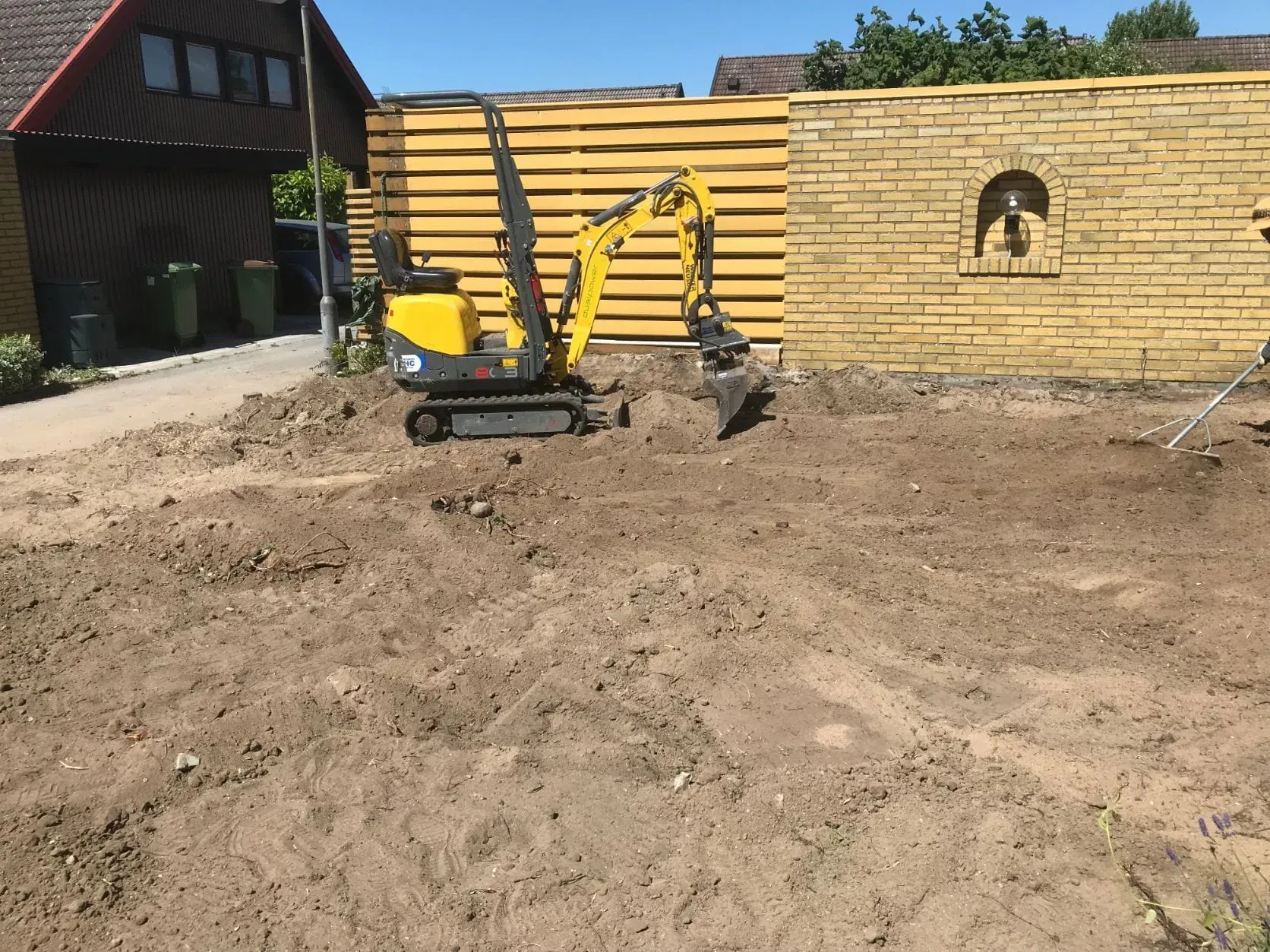 Minigrävare jämnar ut marken inför en ny gräsmatta