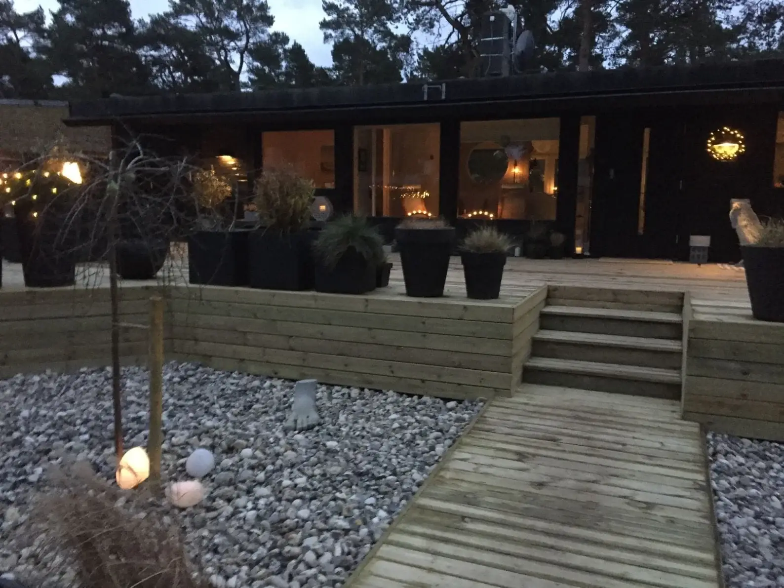 Trädäck, stödmur i trä och stengång i en trädgård i Skåne, byggd av Wood & Stone