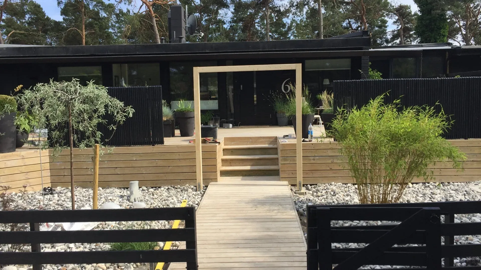 Trädäck, insynsskydd och plantering i skymning, byggt av Wood & Stone